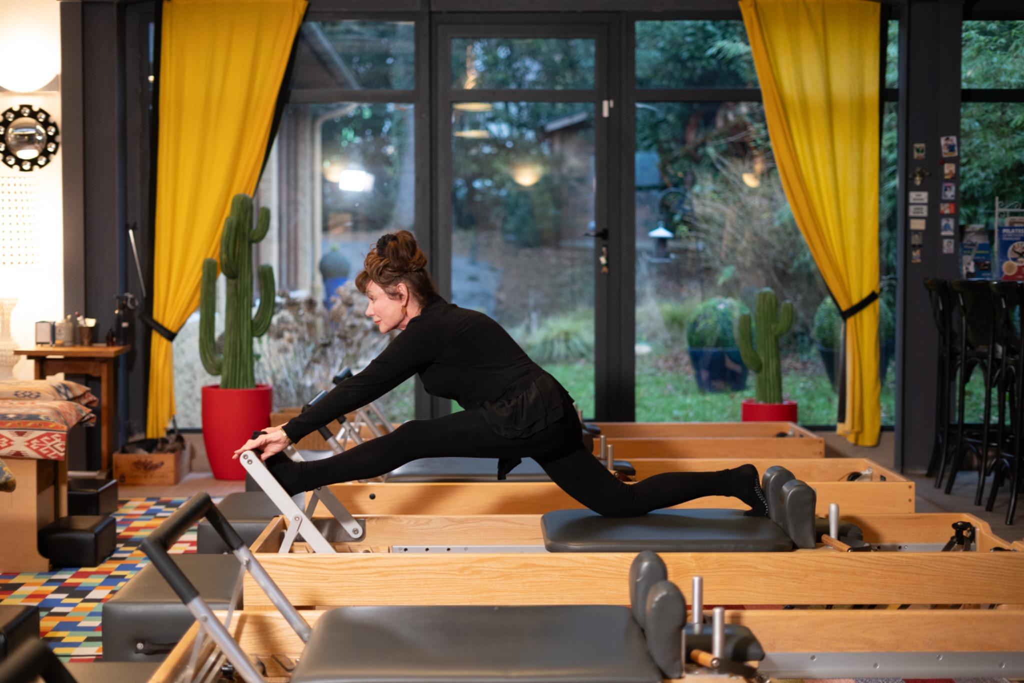 Exercice de Pilates sur Reformer — écarts de face, niveau avancé